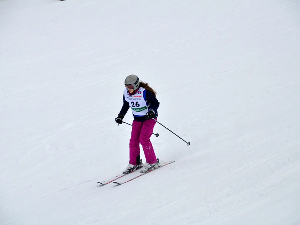 Skifahrerin in pinker Hose auf der Rennstrecke.